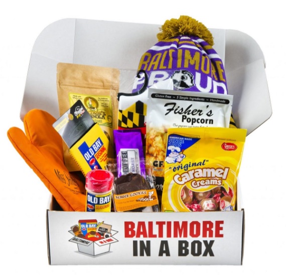 A packed box with a Ravens beanie, Old Bay, Fisher’s Popcorn and Goetze’s Caramel Creams